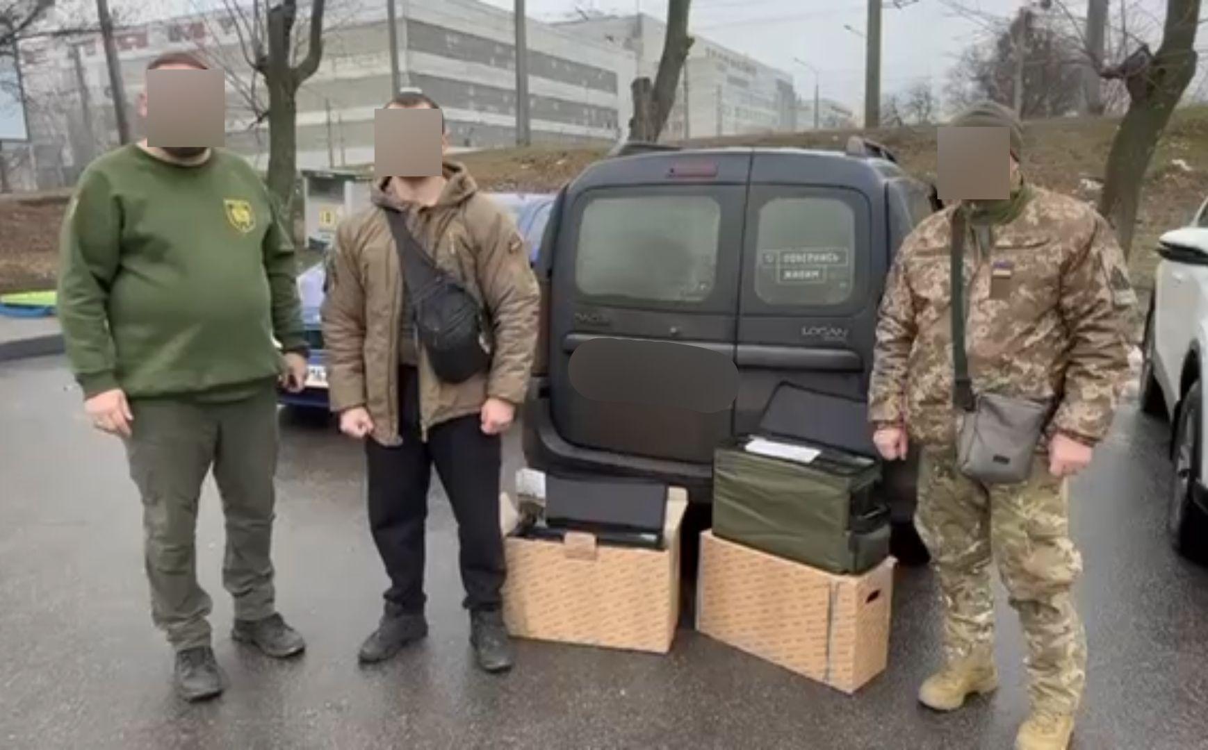 Ukrainian soldiers standing outside with portable power banks